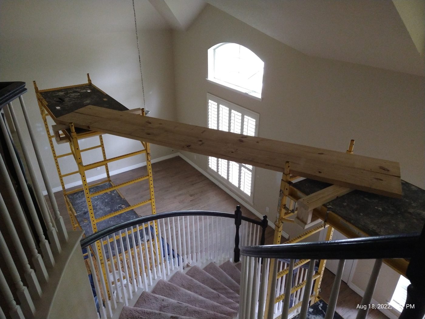 Open staircase and loft with an exposed structural beam and iron railing