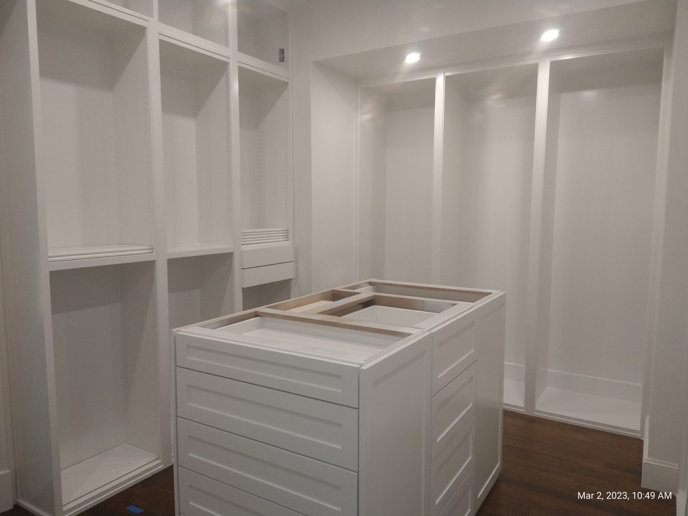 Custom walk-in closet build-out with a full shelving surround and a center island