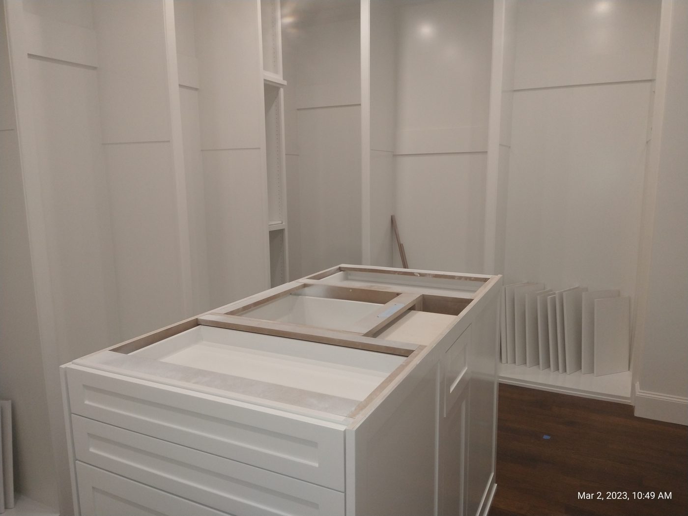 Closet island with a drawer bank and countertop, mid-finish