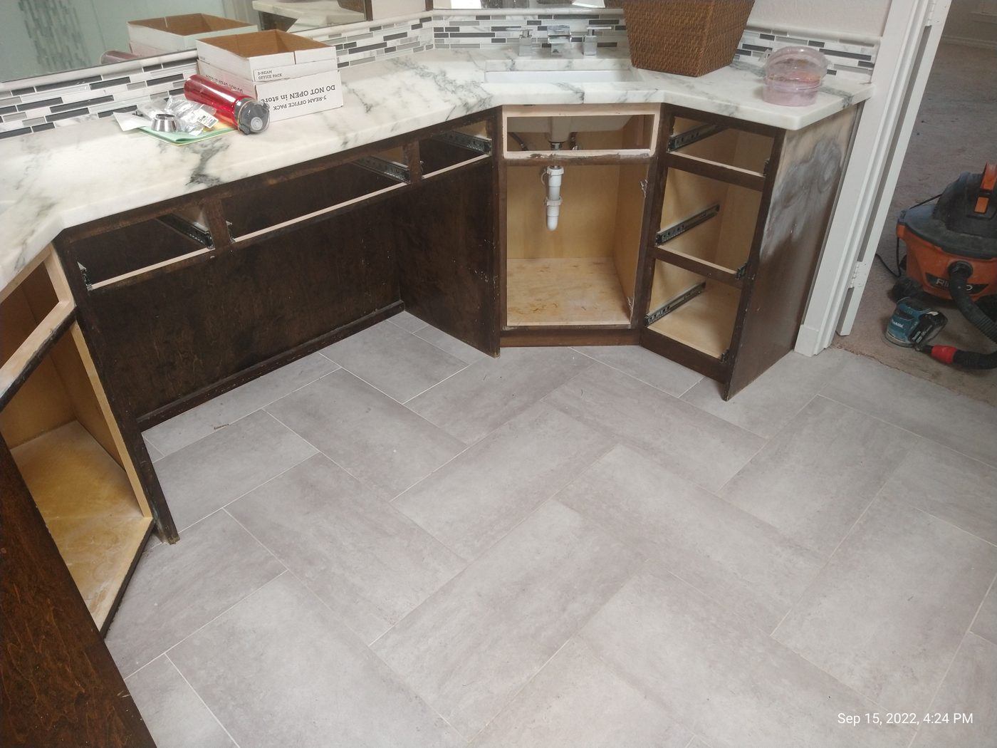 Custom stained built-in cabinetry and shelving over a herringbone tile floor